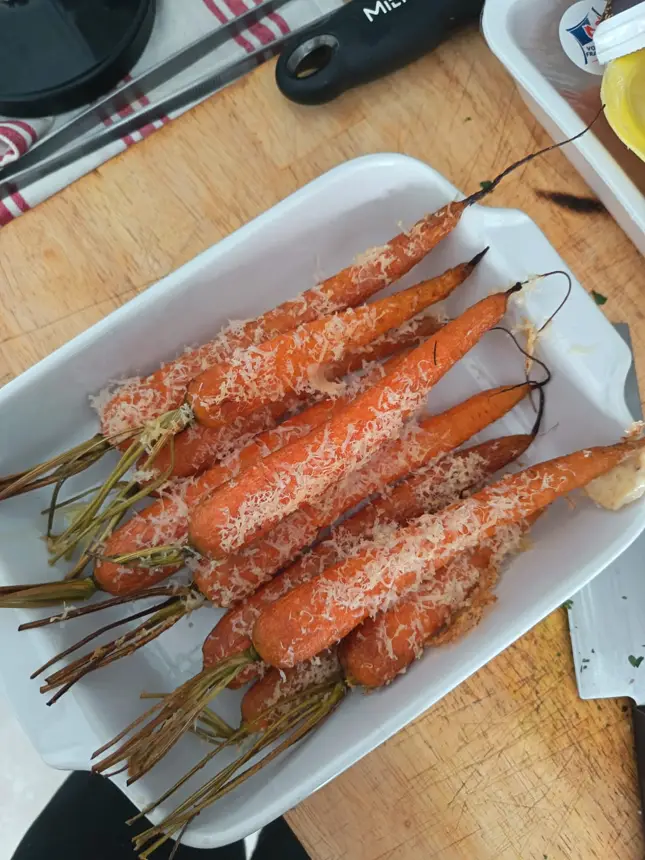 Carottes rôties au fromage râpé sur un plat blanc